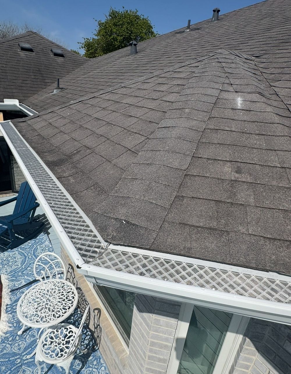 Freshly installed micromesh gutter guards along the roofline of an Upstate South Carolina home under a clear blue sky