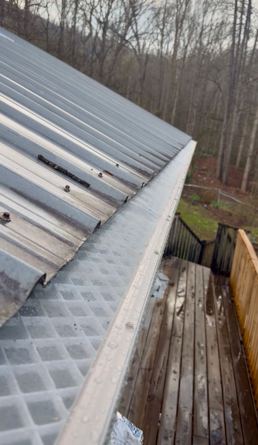 Complete guarded gutter run installed along a metal roof on an Upstate home in the foothills