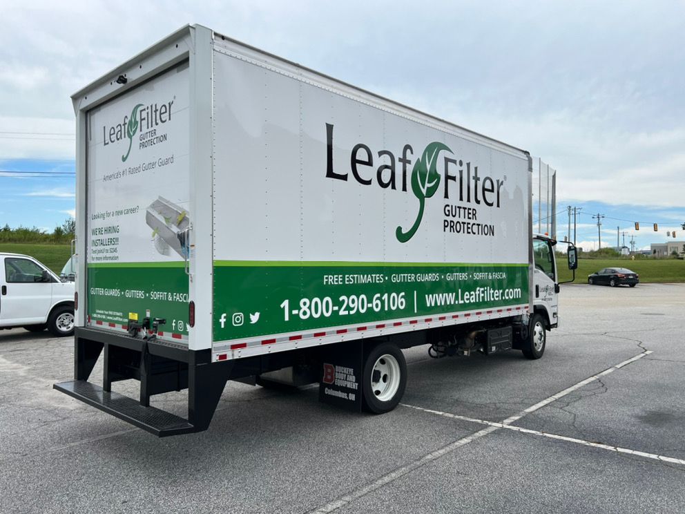 Upstate LeafFilter box truck marked with gutter guard, gutter and soffit services parked before a local job